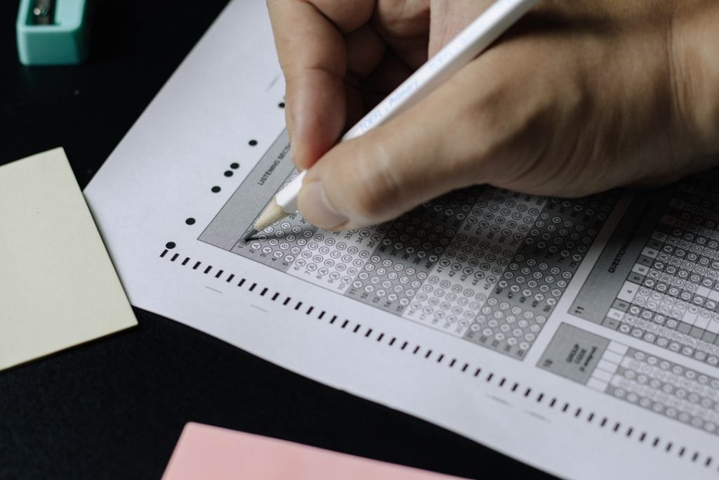 Close-up of a student filling in a multiple choice exam answer sheet with roll number — illustrates the importance of entering the correct roll number when checking BISE results