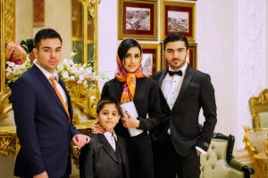 A formally dressed South Asian family gathering, representing the rishta registration process in Pakistan