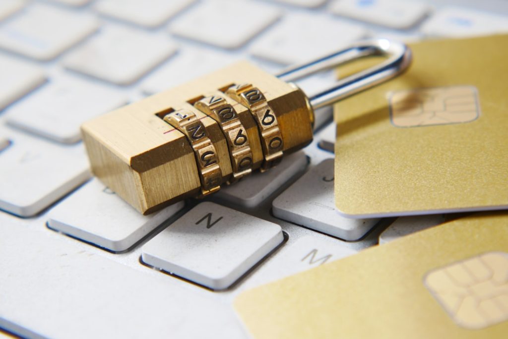 A combination padlock resting on a keyboard with cards, representing digital privacy and data protection in online matrimonial registration