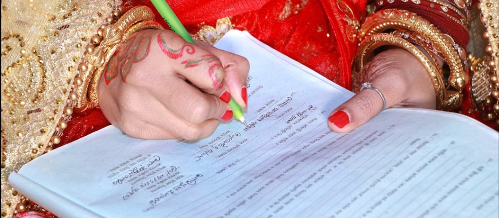 Pakistani bride with henna hands writing a rishta proposal document