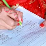 Pakistani bride with henna hands writing a rishta proposal document